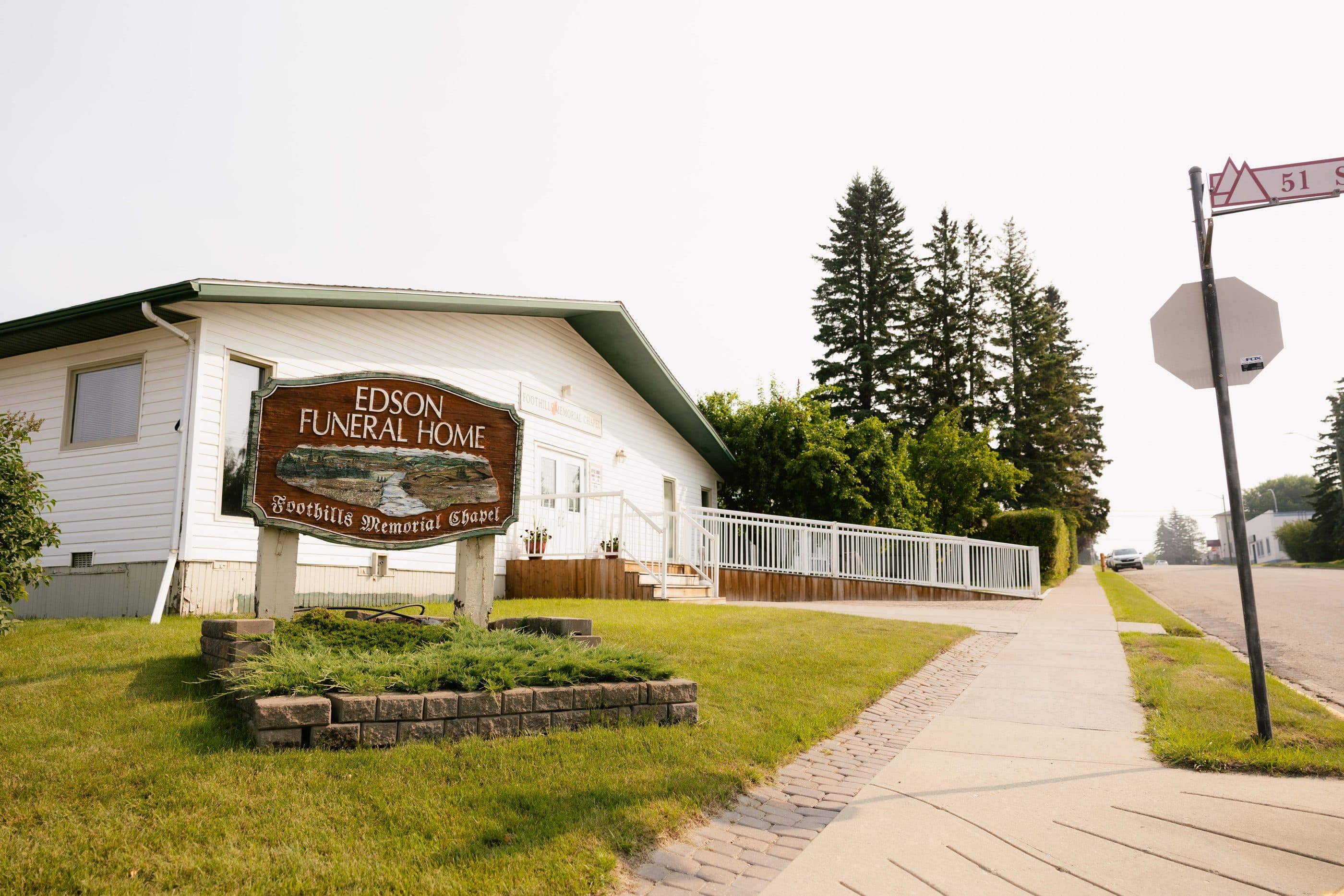 The Edson Funeral Home sign and building on a tree-lined street