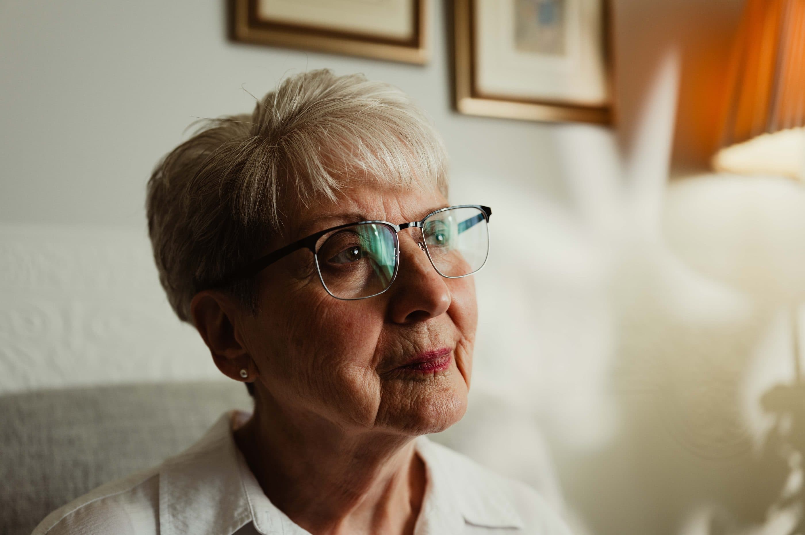 An older woman gazing thoughtfully out of a window