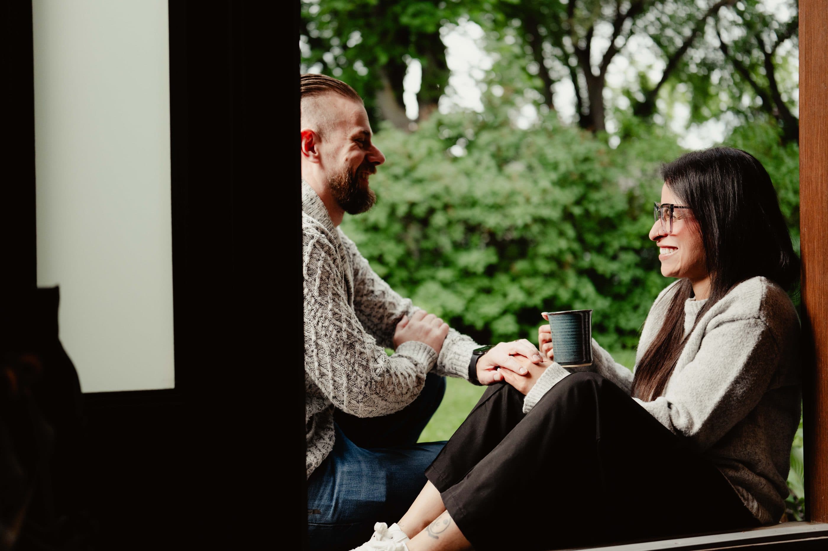 A couple talking together over coffee on a porch